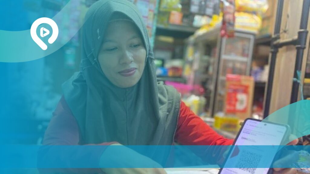 Pengusaha perempuan Indonesia menggunakan smartphone untuk mendukung pengelolaan usaha dan aktivitas penjualan di toko.